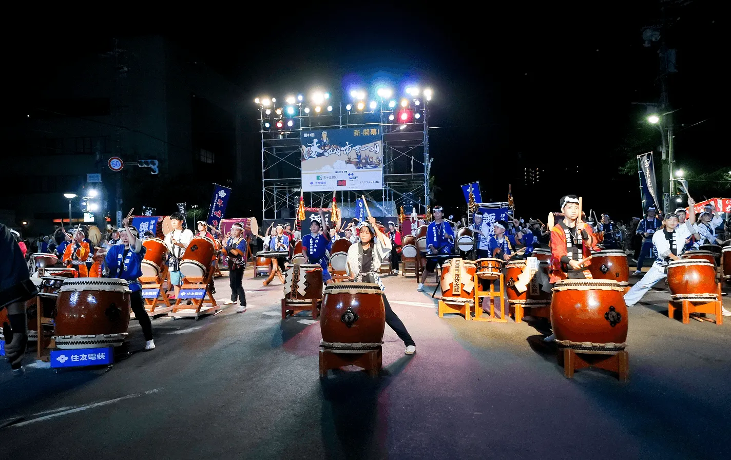 夜間の屋外で和太鼓を演奏する四日市諏訪太鼓の演者たち